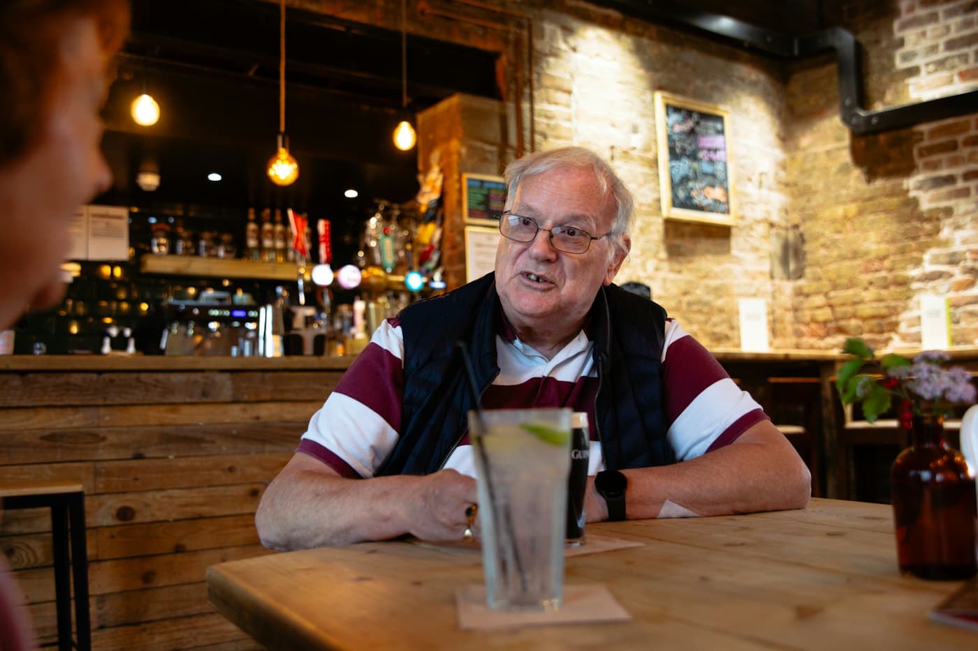 Two people talking across a table in a neighborhood bar